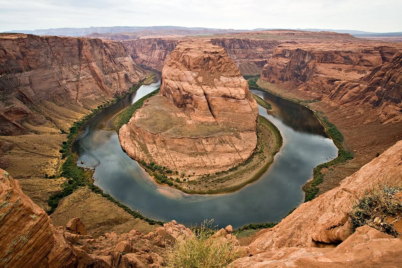 The Colorado River curving in a horseshoe around a sandstone butte at Horseshoe Bend