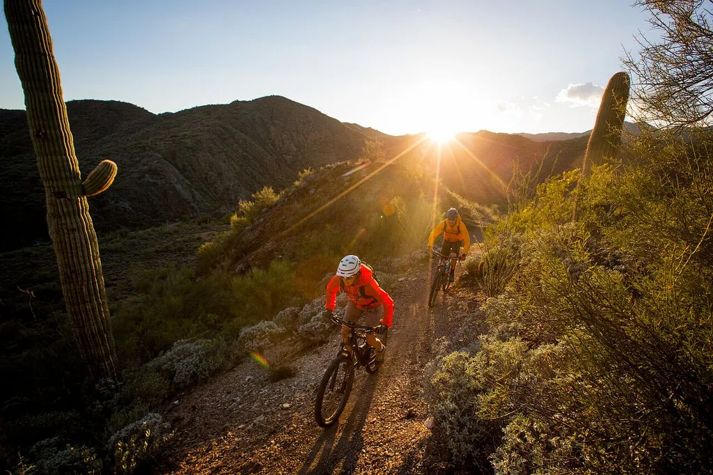 A mountain biker on a desert trail under a blue sky