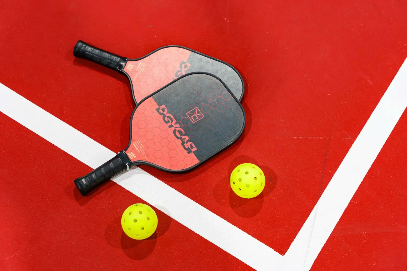 Indoor pickleball court with paddles and balls ready to play