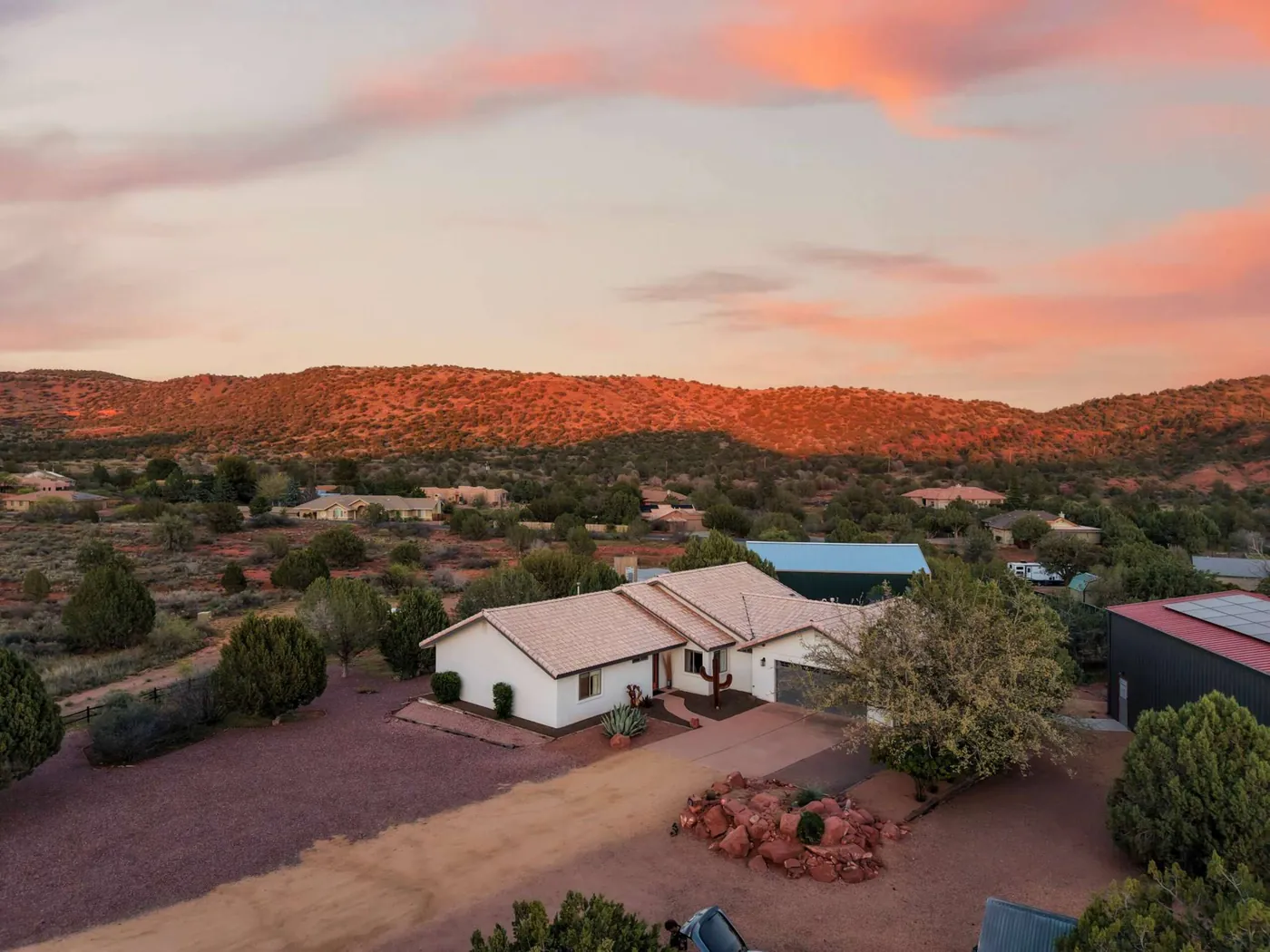 Aerial of the home as sunset lights the surrounding hills